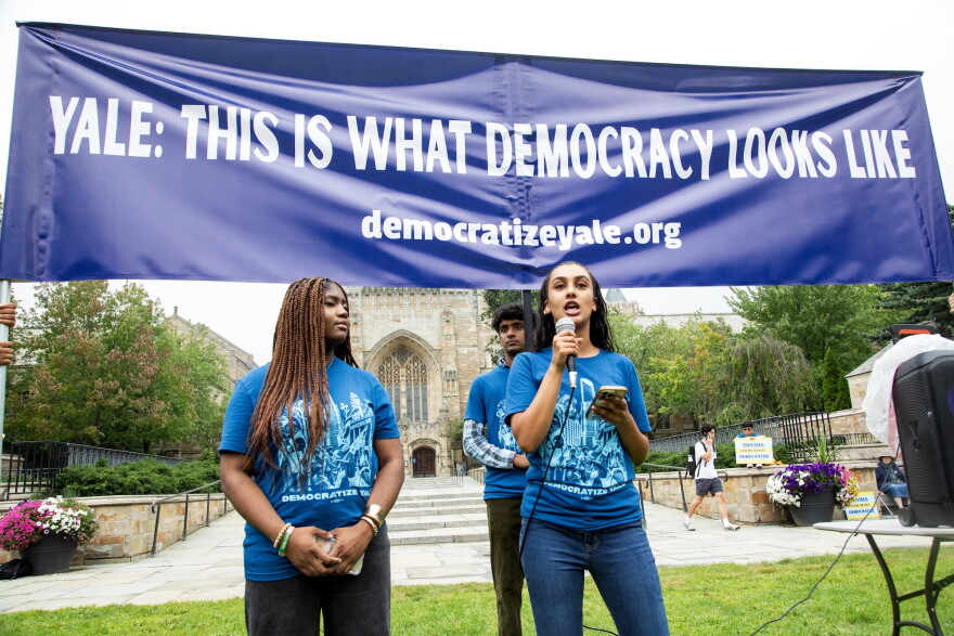 Students with Democratize Yale speak in front of the university's Sterling Memorial Library.