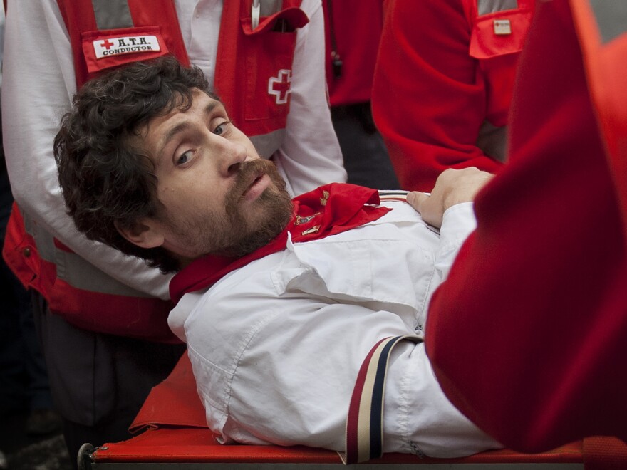 Hillmann, shown here on a stretcher after his injury, says he didn't feel any pain when the bull's horn caught him in the leg.