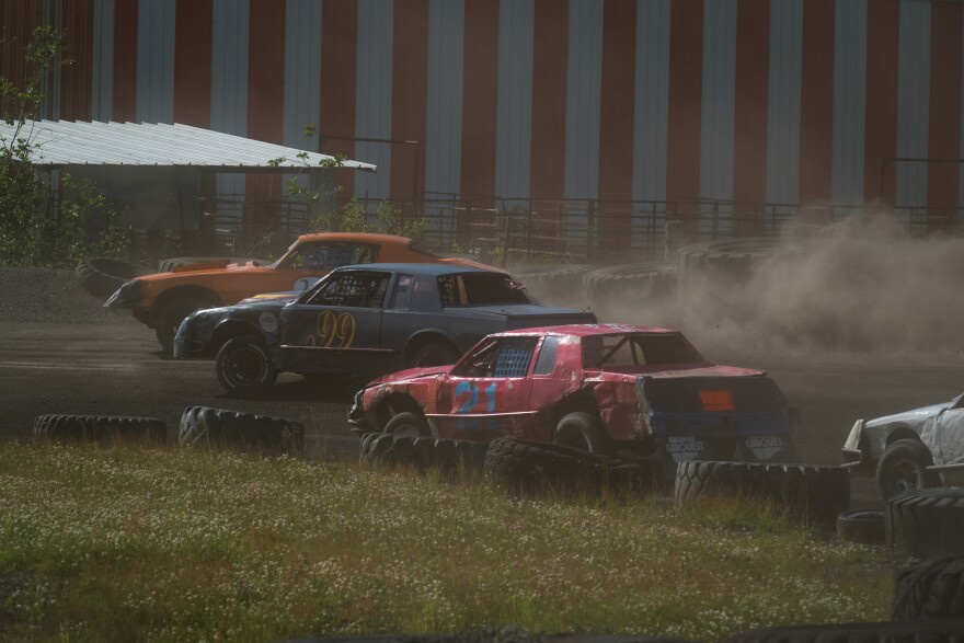Stock cars come around a turn during a race on July 11, 2026.