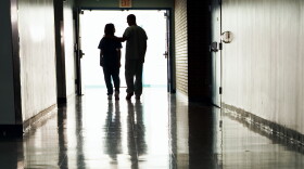People standing at end of corridor in a hospital.