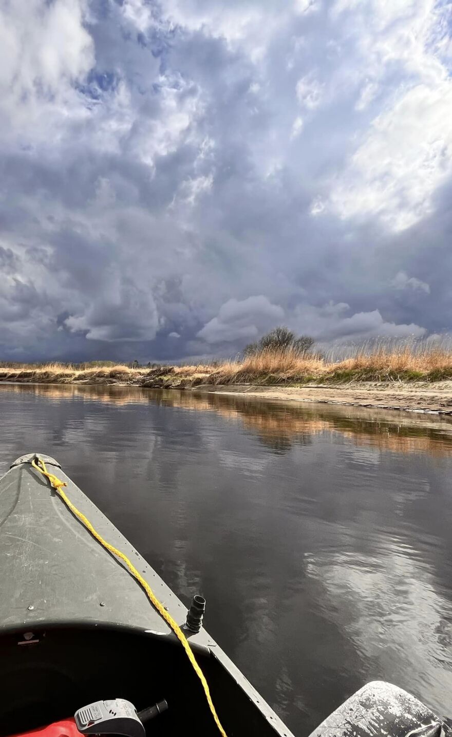 View from a canoe of the Mississippi River with beautiful clouds and reflections in the water.