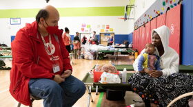 A woman speaks with American Red Cross volunteer Richard Peters.