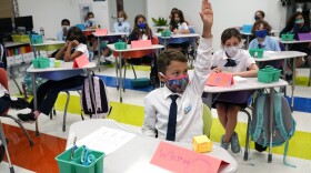 Student Winston Wallace, 9, raises his hand in class at iPrep Academy on the first day of school, Aug. 23, 2021, in Miami. 