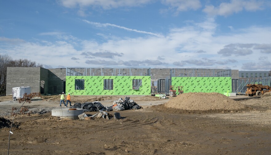 Two construction workers walk the site of Southwestern Illinois College's new advanced manufacturing training facility.