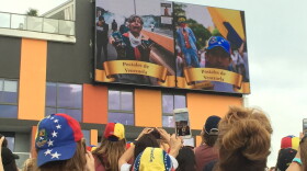 Venezuelan expats watch video of anti-government protesters in Caracas on Saturday at City Place in Doral.