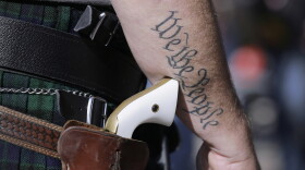 FILE - In this Jan. 26, 2015 file photo, a supporter of open carry gun laws, wears a pistol as he prepares for a rally in support of open carry gun laws at the Capitol, in Austin, Texas.  