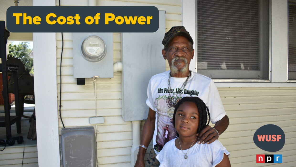 An older Black man with a gray goatee standing on the side of a yellow house, with his left hand on a young girl's shoulder. They're standing in front of a power meter on the house. A grey and yellow text saying "The Cost of Power" to the left 