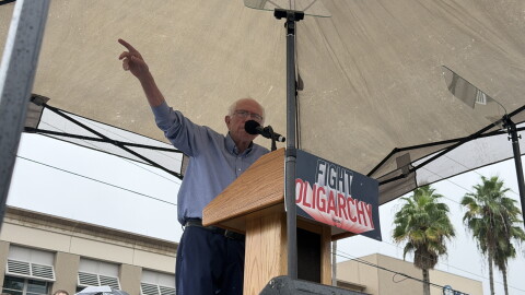 Man gesturing under a tent