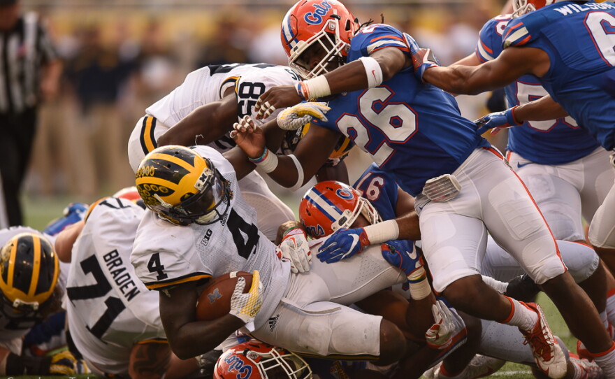 Michigan running back De'Veon Smith (4) is tackled by the Florida defense in the second half. (Greenberry Taylor/WUFT News)