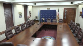An image of the Governor's Large Conference Room at the Capitol Building in Pierre, South Dakota. The room has office chairs arranged around a set of conference tables. 