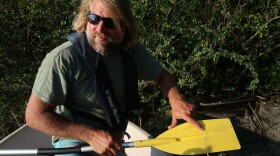 David Burden with the Waterkeeper Alliance points to what he says is coal ash floating on the banks of the Cape Fear River