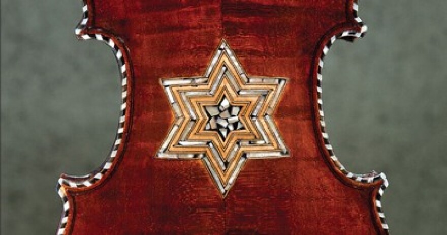 A close-up of the back of one of the Violins of Hope, inlaid with a six-pointed star and trimmed in a black-and-white striped band.