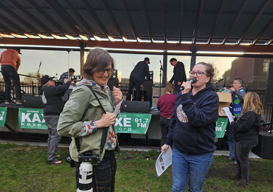 KAXE volunteer photographer Lorie Shaull, left, receives the Debbie Lentz Silent Star Award from News Director Chelsey Perkins at the Kick It With KAXE event on May 16, 2024, at Rapids Brewing Co. in Grand Rapids.