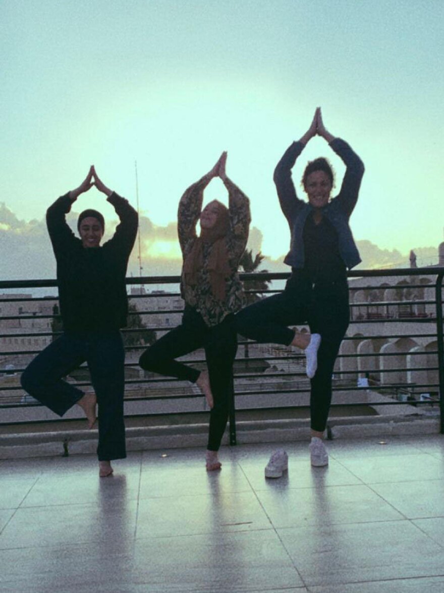 Aysha Abu Shhab (left), Noam Shuster-Eliassi (right) and another patient doing yoga on the hotel terrace.