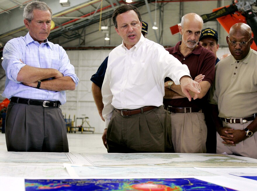 Federal Emergency Management Agency Director Michael Brown (center) briefs President George W. Bush (left) and Homeland Security Secretary Michael Chertoff (second from right) upon their arrival at a U.S. Coast Guard base in Mobile, Ala., on Sept. 2, 2005, before touring the devastation left by Hurricane Katrina.