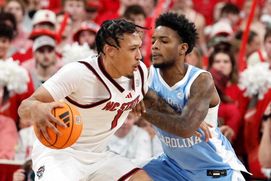 FILE - North Carolina State's Darrion Williams (1) tries to drive the ball around North Carolina's Jaydon Young (4) during the second half of an NCAA college basketball game in Raleigh, N.C., Feb. 17, 2026.