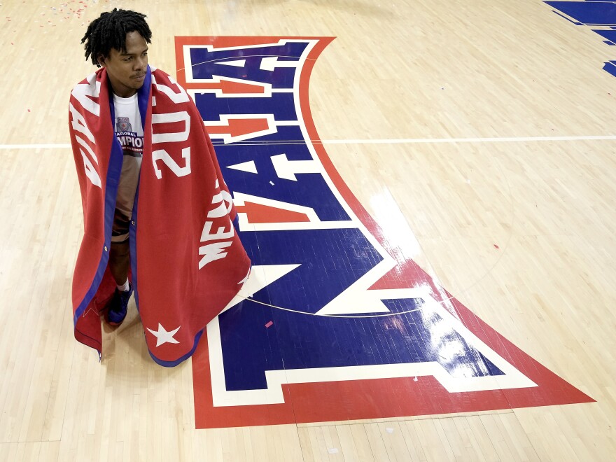 Freed-Hardeman guard Quan Lax wears the championship banner after the NAIA men's national championship college basketball game against Langston, Tuesday, March 26, 2024, in Kansas City, Mo.