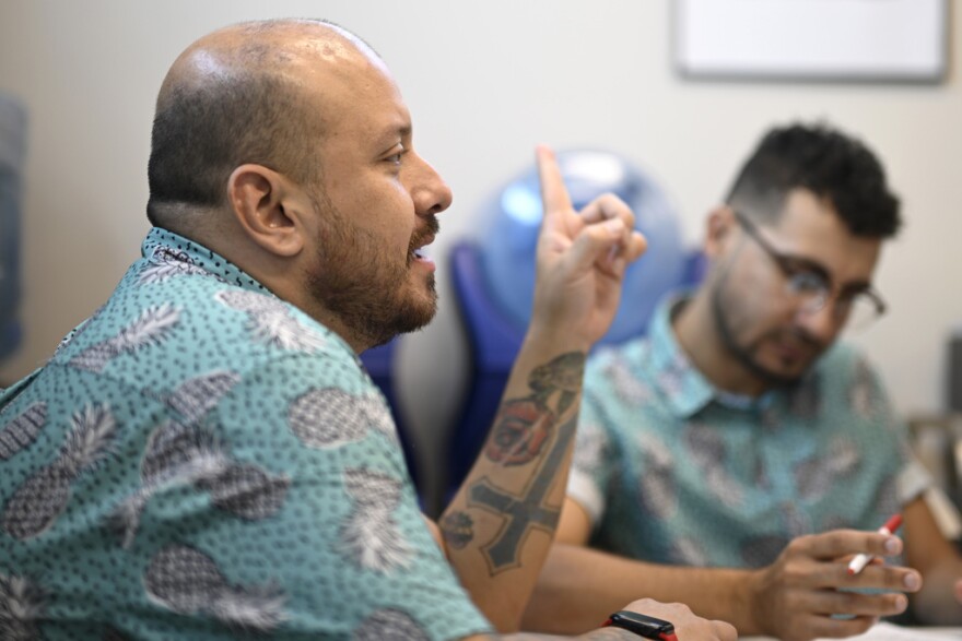 Andres Acosta Ardila, director of community relations at Pineapple Healthcare, speaks during a staff meeting at the medical clinic in Orlando, on May 28, 2024. The clinic'smostly Latino staff is dressed in pineapple-print turquoise shirts, and Spanish, not English, is most commonly heard in appointment rooms and hallways.