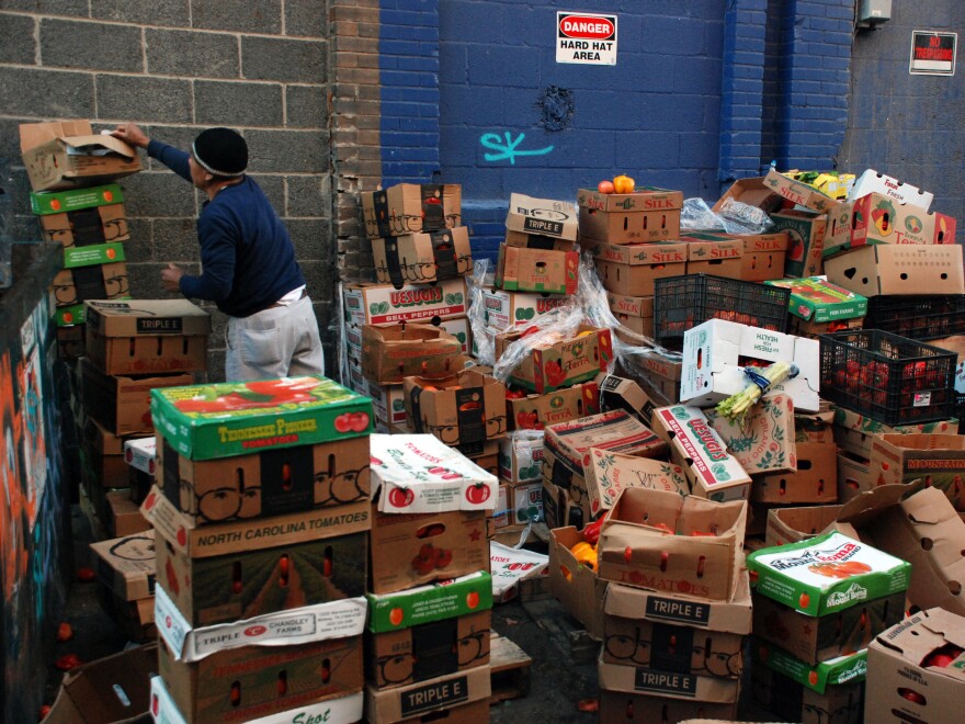 Boxes of unsold produce sit stacked outside Mexican Fruits, a discount grocer. A few loads will be donated to churches but the rest will be thrown away.