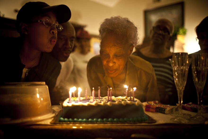 Ida Christian gets help from her granddaughter, Yolanda Hunter (left), in blowing out the candles on the cake celebrating her 89th birthday.