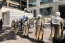 Activists gathered outside the steps of the San Francisco EPA Office donning all black, lab coats, and brown cloth labeled with signs warning of the impacts of climate change.
