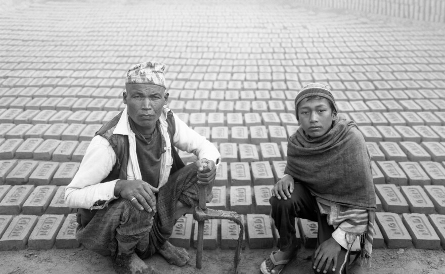 A father and son manufacture bricks from wet clay, then set them out in the cold air to dry before baking them in kilns. Kathmandu Valley, 1987.