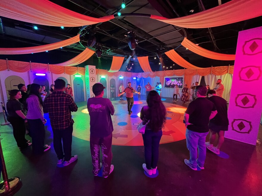 An employee explains the rules of a challenge during the “Squid Game: Survive the Trials” experience inside the newly opened Netflix House Dallas.