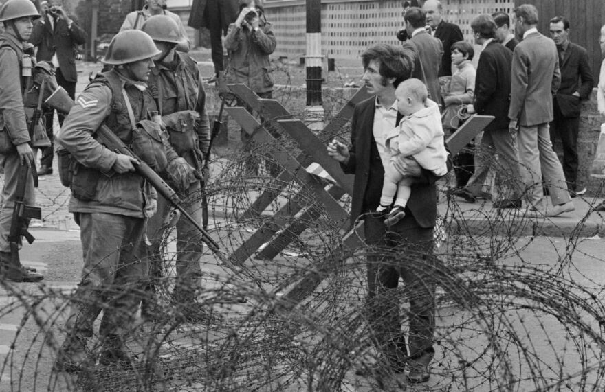 Soldiers and civilians are pictured in Northern Ireland during The Troubles in August 1969.