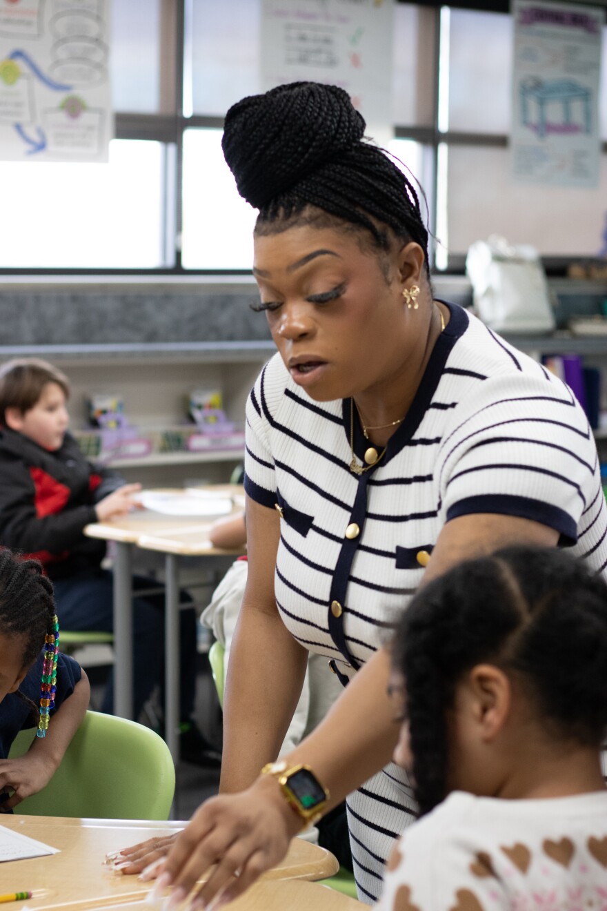 Anderson Elementary teacher Alexis McCane guides a student through sounding out a word as she reads aloud.