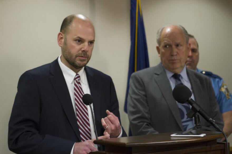 Alaska Deputy Attorney General Robert Henderson speaks to reporters at a press availability on Sept. 15 in Anchorage, as Gov. Bill Walker watches. Henderson said Monday that repealing Senate Bill 91 would be “dangerous.” (Photo by Daniel Hernandez/Alaska Public Media)