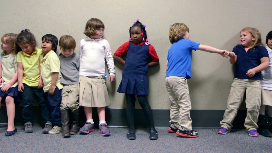 Preschool students from Nikki Jones' class at Porter Early Childhood Development Center in Tulsa line up in the hallway on their way back from outside play.