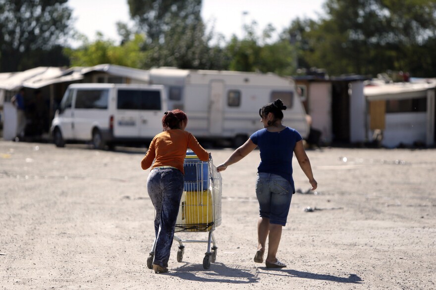 Women from the Roma community push a shopping trolley containing water toward their camp in Sucy-en-Brie, near Paris, in a photo from 2012.