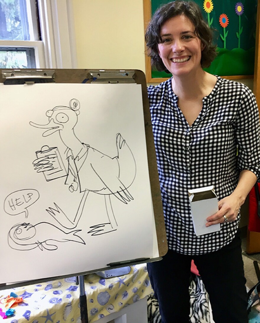 Cartoonist Cara Bean with a duck on an easel
