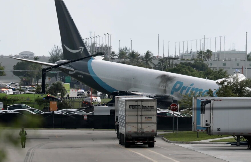 An Amazon cargo plane is seen after it crashed at Miami International Airport on Sunday in Miami. The Federal Aviation Administration said Prime Air Flight 7598 overran the runway while landing around 2 p.m. ET after departing from San Juan, Puerto Rico.