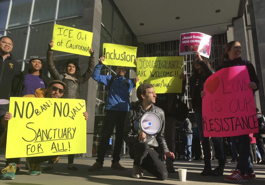 Protesters gather outside a San Francisco courthouse hearing of the first lawsuit challenging President Trump's executive order to withhold funding from so-called sanctuary cities, April 14, 2017.