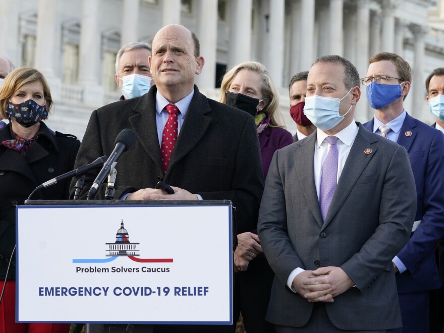 Members of the bipartisan Problem Solvers Caucus — co-chairs Rep. Tom Reed, R-N.Y., at podium, and Rep. Josh Gottheimer, D-N.J., right — took credit for helping to break the logjam on an emergency COVID-19 relief bill.