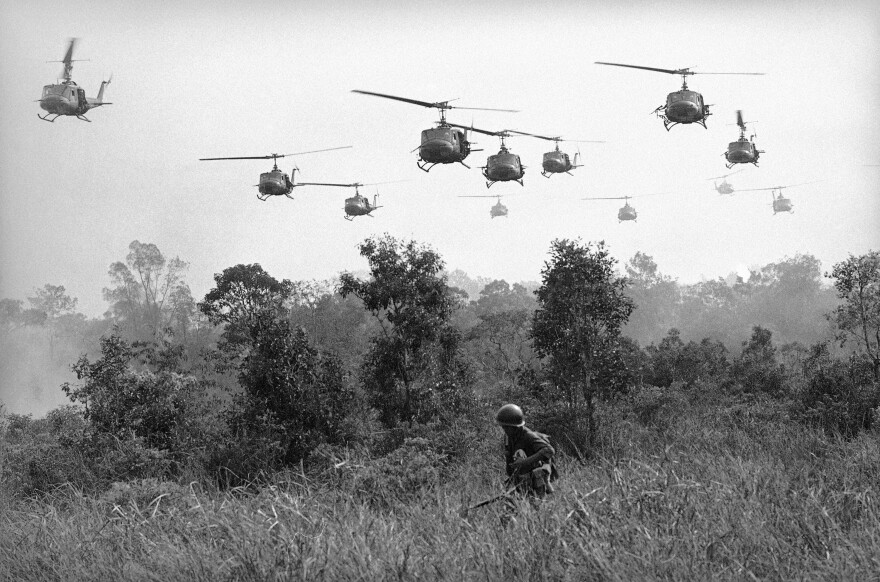 Hovering U.S. Army helicopters pour machine gun fire into tree line to cover the advance of Vietnamese ground troops in an attack on a Viet Cong camp 18 miles north of Tay Ninh on March 29, 1965, which is northwest of Saigon near the Cambodian border. Combined assault routed Viet Cong guerrilla force.