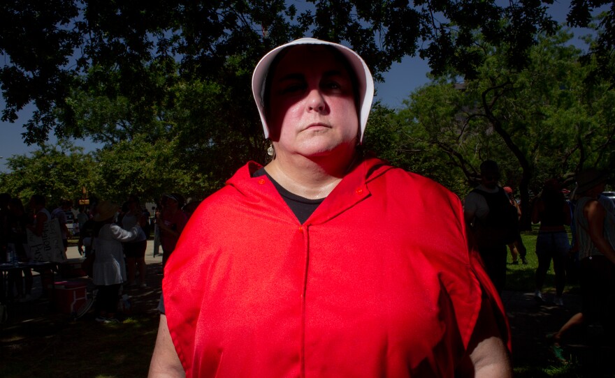 Los Angeles-based filmmaker Pamela Torrance stands outside of the Tarrant County Courthouse, dressed in an outfit similar to what characters wore in the Hulu series "The Handmaid's Tale", a series set in a totalitarian and theocratic state that subjugates women. Torrence is working on a documentary featuring anonymous stories of women’s abortion/reproductive experiences.