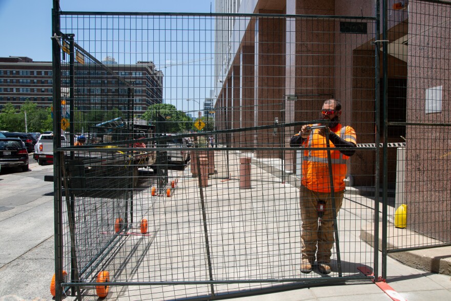 An employee from a fence rental company puts up a protective barrier around the Earle Cabell Federal Building in Dallas on Friday, in anticipation of protests following Friday's Supreme Court decision to overturn Roe v. Wade.