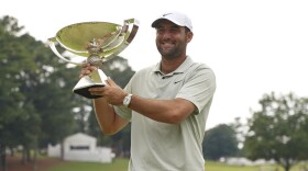 Scottie Scheffler poses with the FedExCup Trophy after the final round of the Tour Championship golf tournament, Sunday, Sept. 1, 2024, in Atlanta. (AP Photo/Jason Allen)