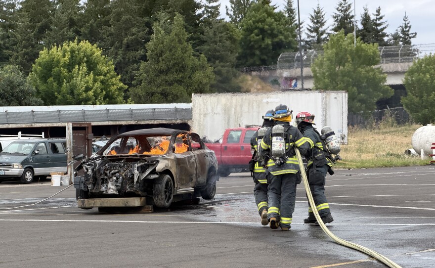 Two campers and an instructor practice extinguishing a car fire at Young Women's Fire Camp, June 25, 2026.