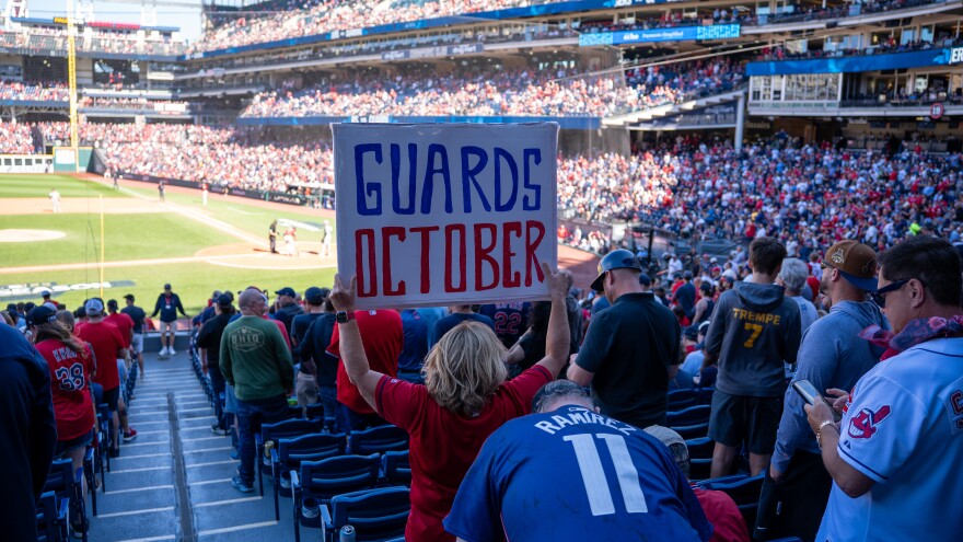 Girl holds sign at baseball game that says Guards October