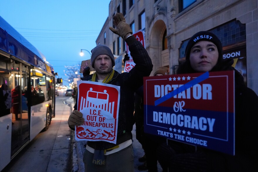 Demonstrators hold signs during a rally against federal immigration enforcement on Wednesday, Jan. 28, 2026, in Minneapolis. (AP Photo/Julia Demaree Nikhinson)