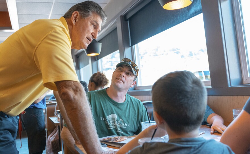 Democratic Sen. Joe Manchin (left) speaks to Jason and Loarie Butcher of Pinch W.Va., last month at an IHOP restaurant in Charleston, W.Va., about his recent vote in the Senate to confirm Supreme Court Justice Brett Kavanaugh.