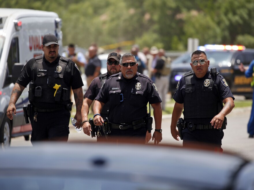 Police walk near Robb Elementary School in Uvalde, Texas, following a shooting Tuesday.