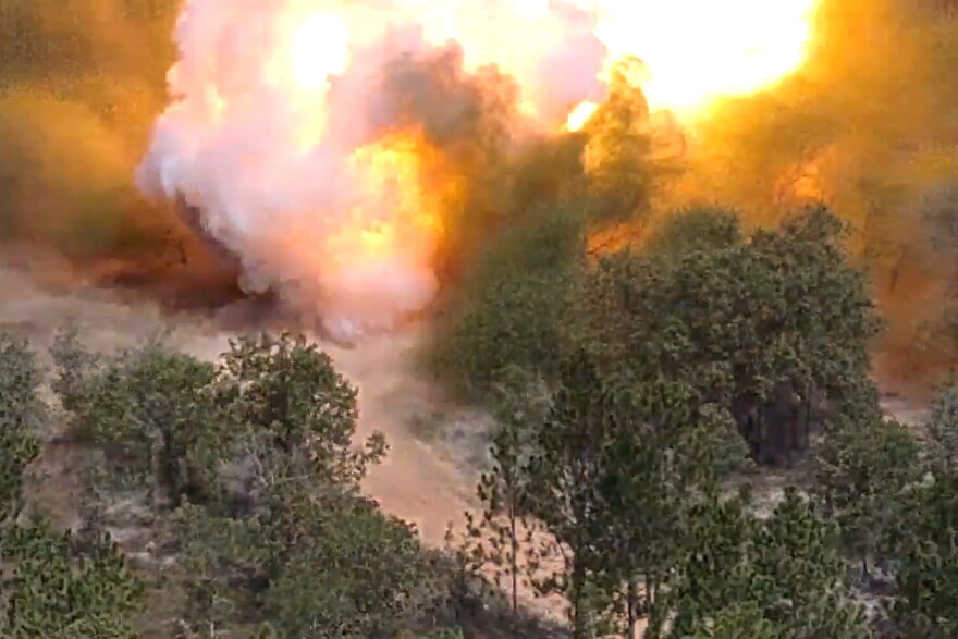 In a screenshot of a video captured by a Black Widow drone, an autonomous weapon system fires an explosive charge at Fort Bragg, N.C. The August 21 demonstration showed the potential of the unmanned system to cut a path through a minefield, a dangerous operation that normally risks soldiers' lives.