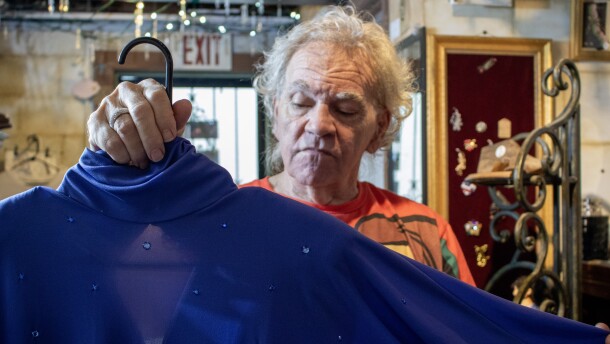 Harold Alexander examines a dress inside his resale store, Artier. His shop was damaged in the June 14 flash floods, which has forced him to reexamine the future of the store.