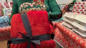 Durante una fiesta navideña, Bamaca elige una manta roja y peluda de un montón de regalos. Llegó a Estados Unidos hace más de dos décadas y no ha podido celebrar las fiestas con sus padres desde entonces.