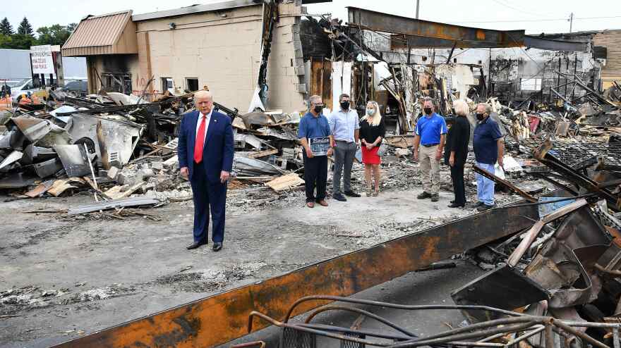 President Trump tours an area affected by civil unrest in Kenosha, Wis., on Tuesday. While there, he attacked Democratic leaders in other nearby big cities, saying they aren't doing enough on crime.