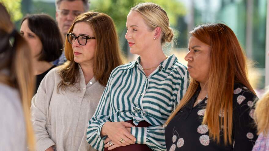 Dr. Austin Dennard, center, stands between fellow plaintiffs, Dr. Damla Karsan, left, and Samantha Casiano, outside a courthouse in Austin where their case was heard on July 20.